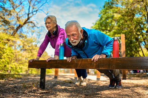 Seniors couple in sports clothing working stretching and exercise in the park