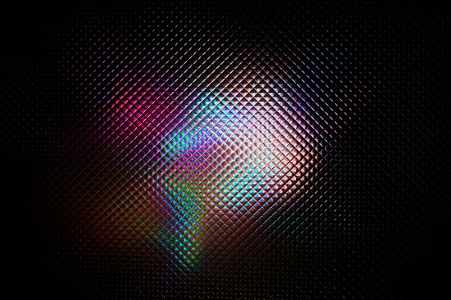 Multicolored abstract colorful pattern. Light glares with spectral gradient on a dark background.