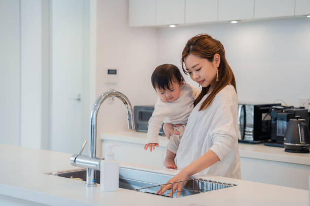 istock Mother doing household chores while carrying baby 1443004728