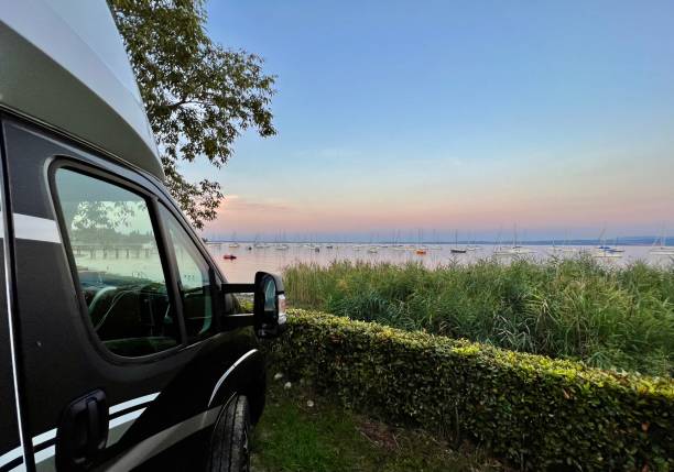 イタリアのガルダバルドリーノ湖のキャンプ場にあるキャンピングカー - lake garda sunset blue nautical vessel ストックフォトと画像