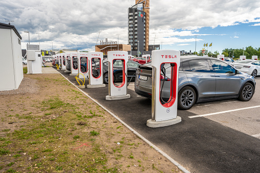 Halmstad, Sweden - July 10 2022: Long row of Tesla cars charging at Tesla Supercharger Halmstad.