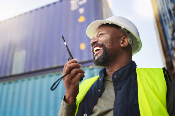 istock Logistics, supply chain and radio with a man delivery worker talking on a walkie talkie while working in a container yard. Ecommerce, stock and cargo in the retail, shipping and export industry 1443009682