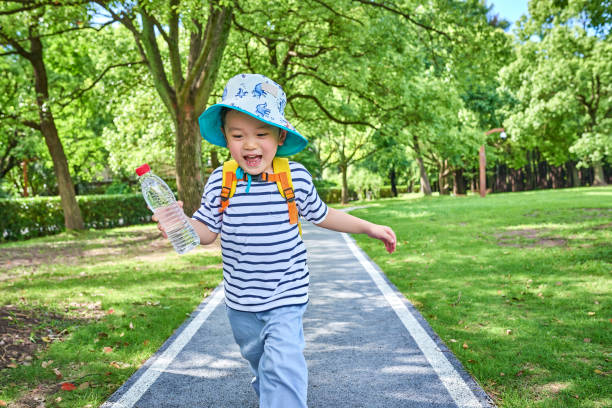 Close-up of one cute little boy running at footpath by outdoors.