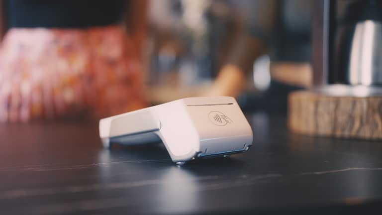 Close-up of customer paying for service using smartphone, cashless payment