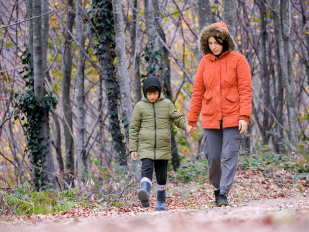 istock A mother and her son are having a walk in forest 1443023216