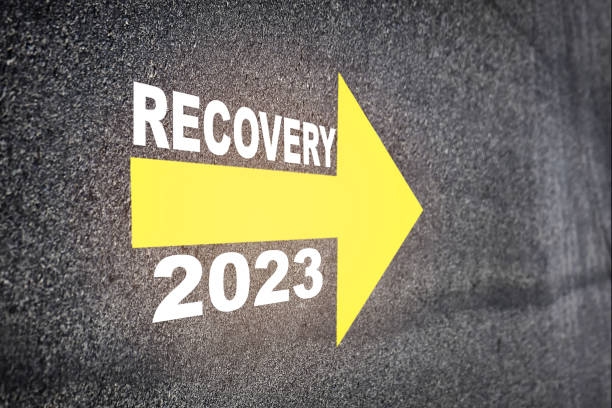 istock Recovery 2023 with yellow arrow marking on road surface 1443024691