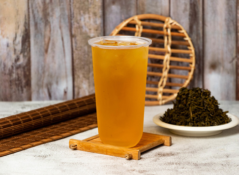 Green tea served in disposable cup isolated on table side view taiwan style