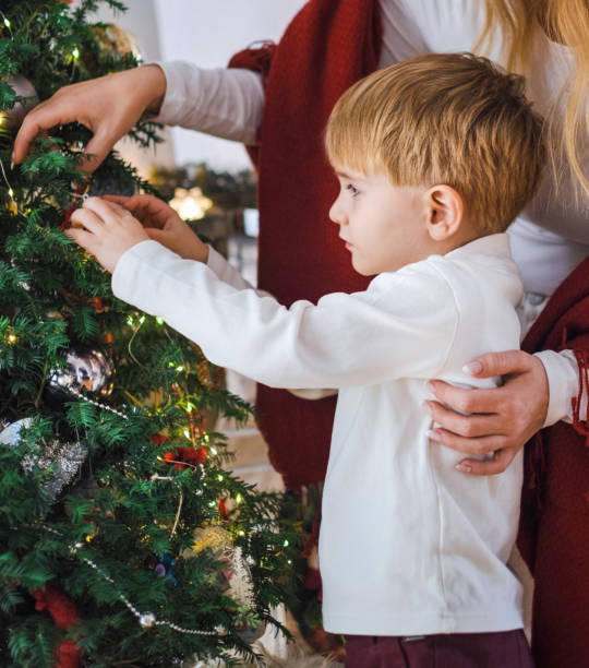 istock a child with his mom decorating the Christmas tree 1443030019