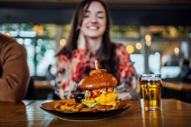 istock Smiling woman looking at burger at a restaurant 1443031758
