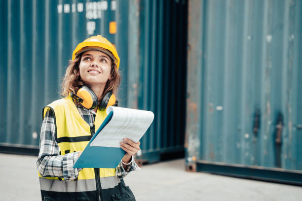 istock Female foreman wearing a helmet inspects a container. 1443031855