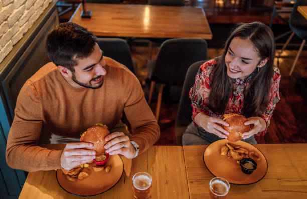 istock Young couple enjoying burgers 1443031861