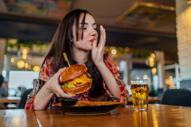 istock Young woman enjoying a delicious burger 1443032134