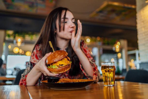 Young woman enjoying a delicious burger stock photo