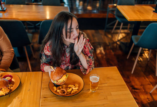 istock Young woman enjoying a delicious burger 1443032163