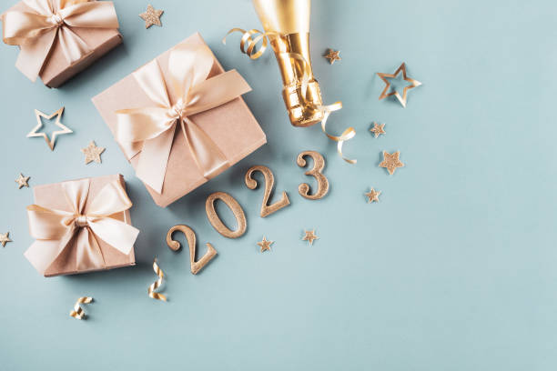 Golden gift or present boxes, 2023 numbers and Christmas decorations on blue turquoise background top view. Flat lay composition for New Year. stock photo
