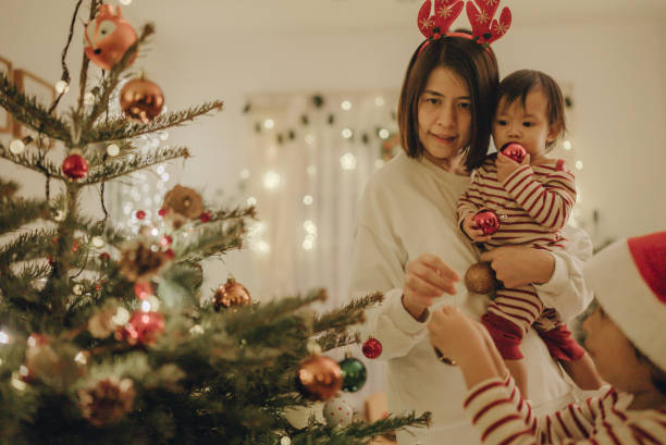 istock Little boy and young woman decorating christmas tree. 1443037219