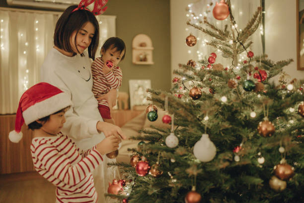 istock Little boy and young woman decorating christmas tree. 1443038402