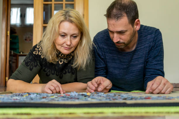 istock Adorable couple doing a puzzle lying on the floor, they enjoy their company while spending some fun time together. 1443039937