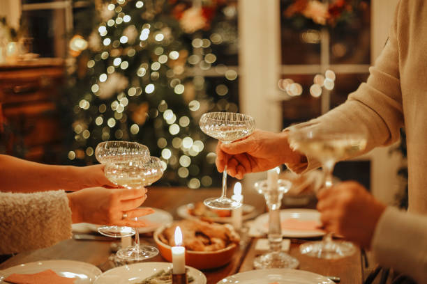 szczęśliwi przyjaciele brzęczący kieliszkami szampana podczas świętowania sylwestra lub bożego narodzenia - toast party champagne dinner zdjęcia i obrazy z banku zdjęć