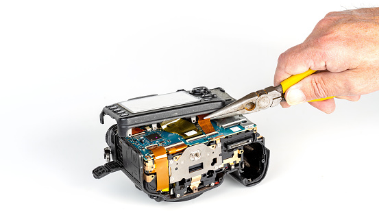 Camera repair closeup with tools and disassembly