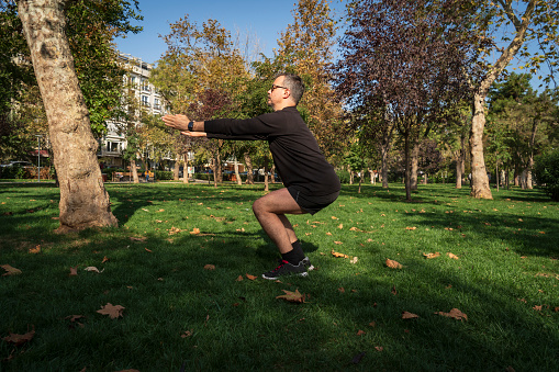 Mature man stretching in the park before jogging
