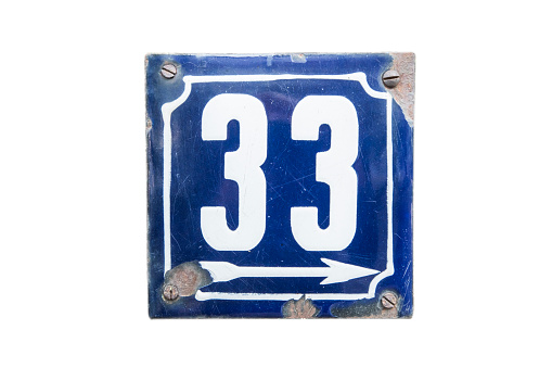 Weathered grunge square metal enameled plate of number of street address with number 33 isolated on white background