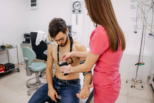 el médico coloca un holter en el pecho de un hombre - pulse trace electrode human heart holter fotografías e imágenes de stock