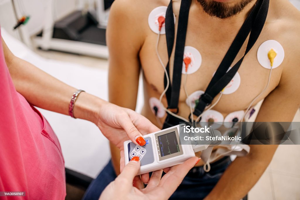 Man with heart problems on the visit to doctor Nurse puts electrodes on man patient to do electrocardiogram Electrocardiography Stock Photo Man with heart problems on the visit to doctor Nurse puts electrodes on man patient to do electrocardiogram Electrocardiography Stock Photo