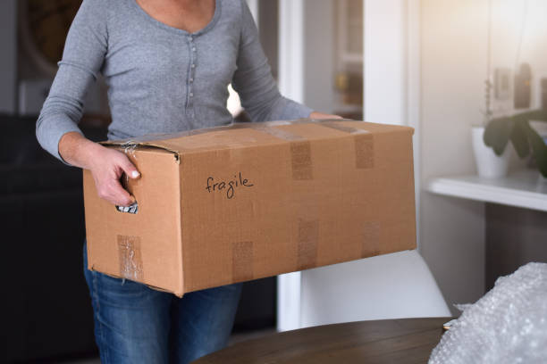 istock Woman carrying cardboard box packed for moving 1443052684