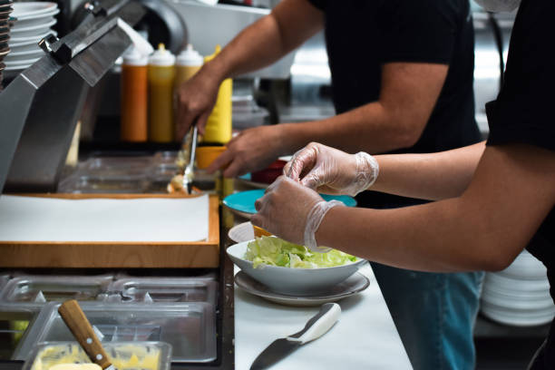 istock Kitchen employees working on a customer food order 1443053782