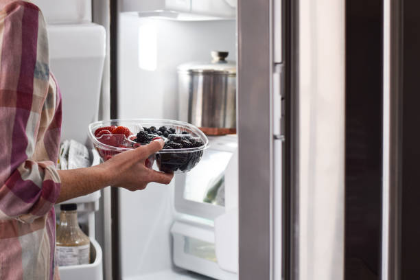 istock Woman taking container with fresh berries from refrigerator 1443053828
