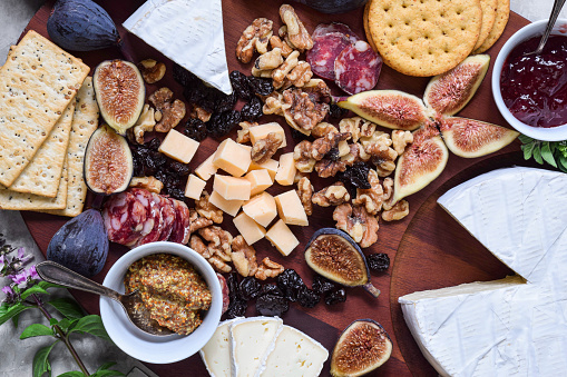 Top down view of cheese fruit and cured meats charcuterie board closeup