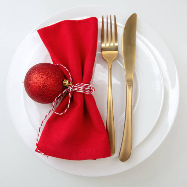 istock Christmas table setting, celebration dinner. Golden cutlery and red napkin isolated on white, overhead 1443056726