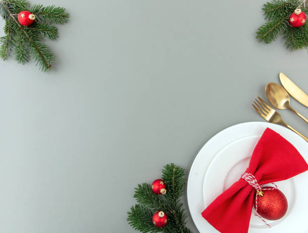 istock Christmas table setting, celebration dinner. Golden cutlery and red napkin on gray, overhead 1443056781