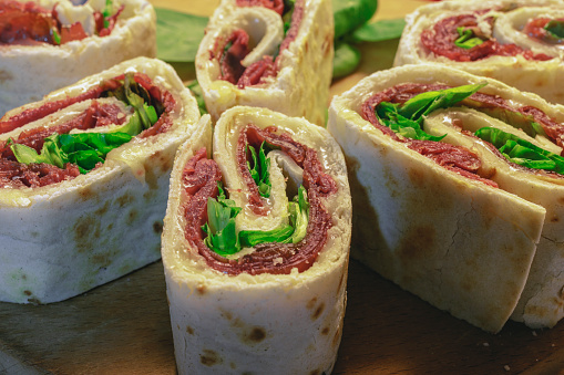 A rolled piadina with bresaola cheese and salad