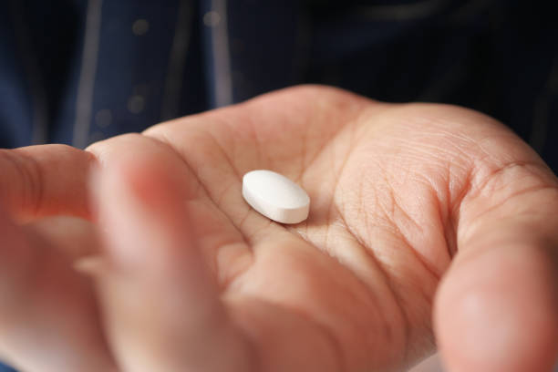 istock Close up of man hand holding pills with copy space 1443057671
