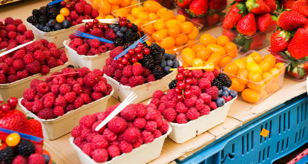 istock Fresh Berries such as red currant, blackberry, raspberry, strawberry and blueberry in transparent rectangular plastic containers of the same size put in line into a paper pallet ready to sell 1443058735