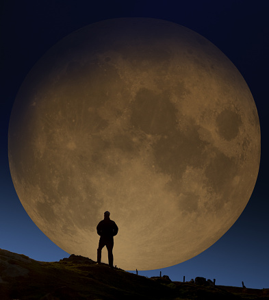 Man backlit by moonlight at night