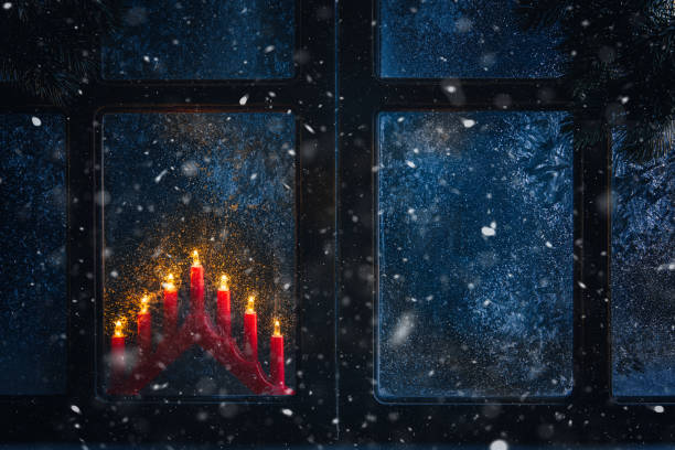 istock Christmas, winter composition. Christmas Candles behind a frozen window 1443062300