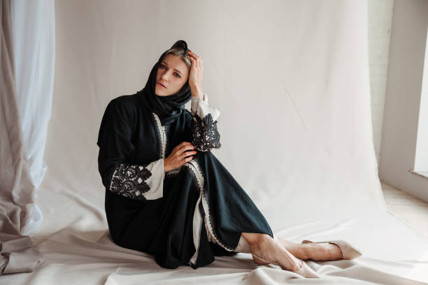 Beautiful muslim woman in traditional arabian abaya dress on gray background stock photo