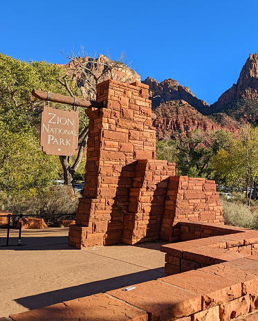 A public sign welcoming visitors to Sedona with the famous red rocks in the background.