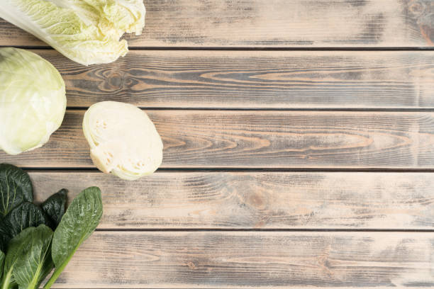 food mockup of slices of cabbage with lush foliage on wooden background. advertisement of natural, organiñ store, market - organi imagens e fotografias de stock