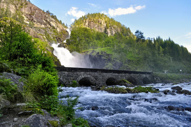 stone bridge over latefossen waterfalls in norway - bridge norway odda falling imagens e fotografias de stock