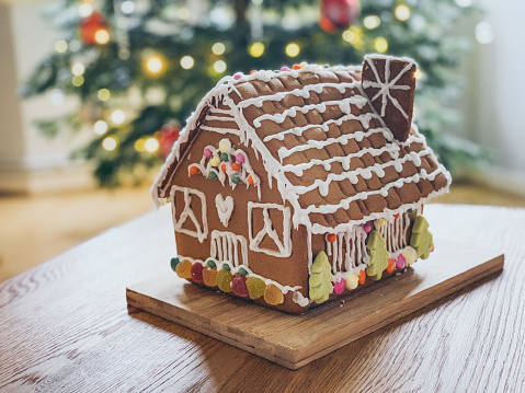 Decorated christmas gingerbread house in homely cozy atmosphere. Preparing to celebrate Christmas.