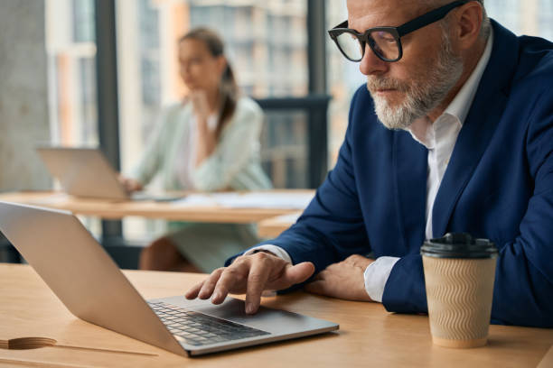 istock Aging businessman looking at laptop screen seriously while concentrating 1443082412