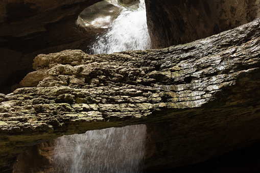 Saltinsky waterfall in Salta, Dagestan, Russia. Turbulent water flow in motion. Underground cascade. Jets of water fall into the lake