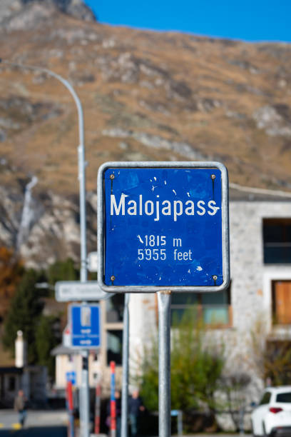 Sign indicating the summit of Maloja Mountain Pass in Switzerland Plate along the road showing that the top of the Malojapass has been reached at an elevation of 1815 meters (5955 feet). maloja region stock pictures, royalty-free photos & images