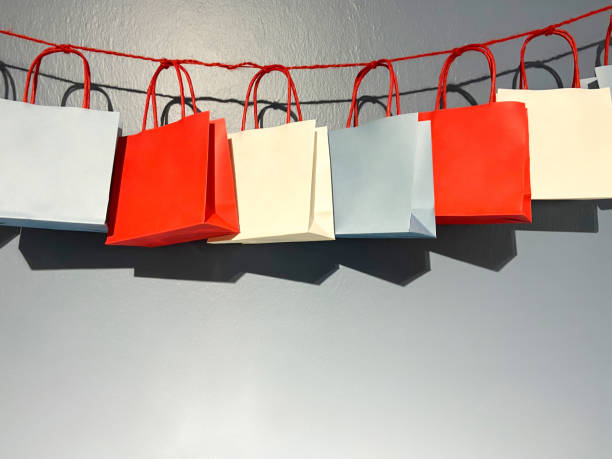 Group of multi colored gift bags hanging on the wall. Shopping bags
