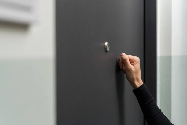 Woman hand knocking on the metal door stock photo