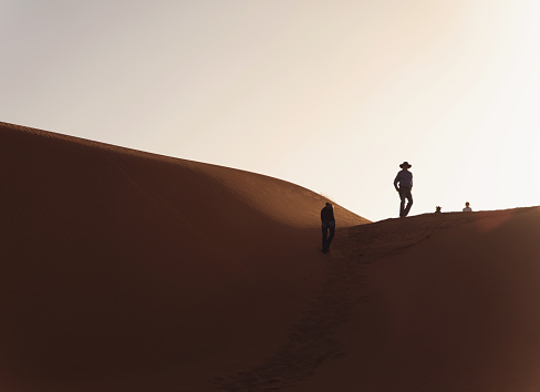 A man walking alone in the dunes early morning from Dubai